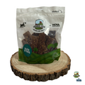 Bag of Paddock Farm duck strips dog treats on a wooden stand with visible branding.